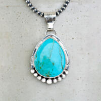 Front hanging view large blue turquoise pear cabochon bezel set accented with beads and stamped wire on oxidized navajo pearls 